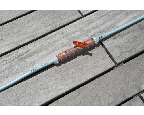 Furtun de grădină cu robinet de închidere pe terasă de lemn