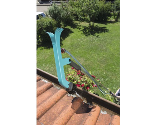 Curățător de jgheaburi în uz pe un acoperiș