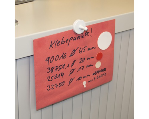 O foaie de hârtie roșie cu informații despre puncte adezive, fixată cu un magnet alb.