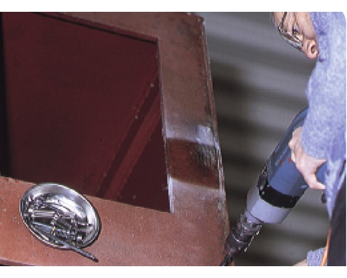 Artizan care lucrează cu o mașină de găurit pe o structură de oțel