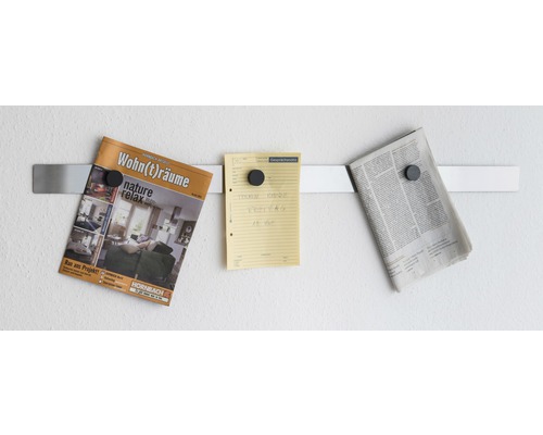 Bară magnetică pe perete cu revistă, notiță și ziar atașate