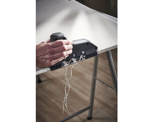 O persoană folosește un rindel de muchii pe o placă de gips-carton pentru a crea o margine curată.