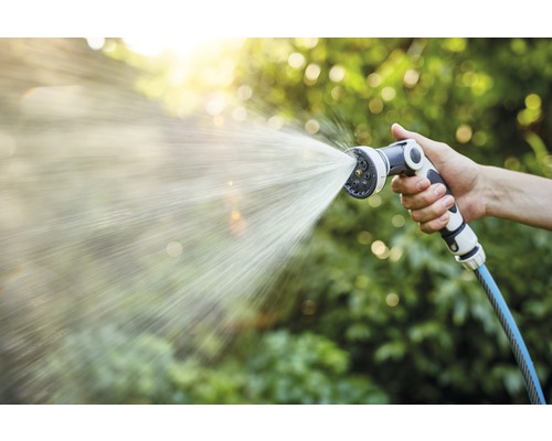 Mână ținând furtun de grădină cu cap de pulverizare