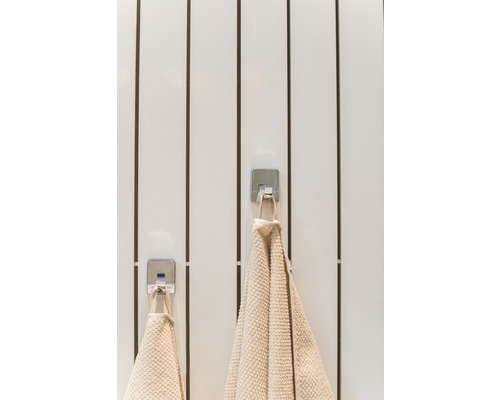 Două prosoape atârnă pe cârlige în baie