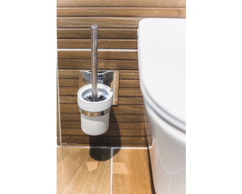 Perie de toaletă și vas de toaletă într-o baie