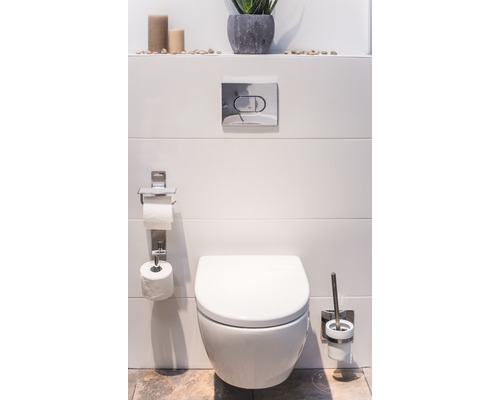 Baie modernă cu toaletă suspendată, suport pentru hârtie igienică și set de perii pentru toaletă.