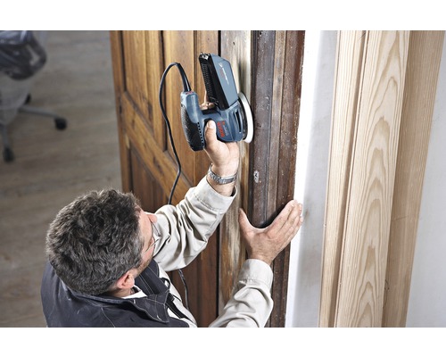 Bărbat șlefuind un toc de ușă din lemn cu o șlefuitoare multifuncțională