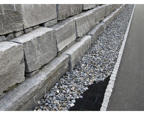 Un zid din piatră naturală cu un strat de pietriș