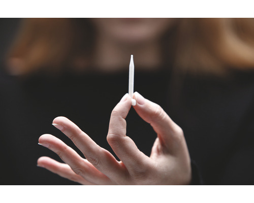 O mână ține un injector.