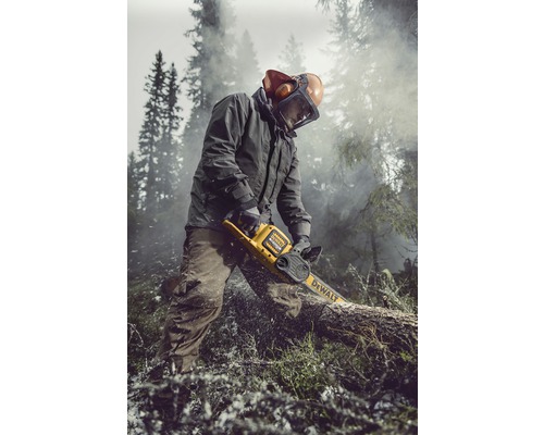 O persoană taie un trunchi de copac cu un lanț de fierăstrău cu acumulator DeWalt. Persoana poartă îmbrăcăminte de protecție și lucrează afară.