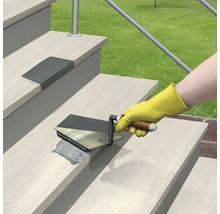 O persoană repară o treaptă cu o spatulă.