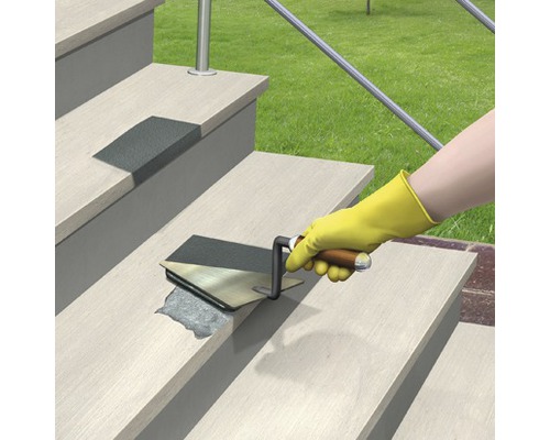 O persoană repară o treaptă cu o spatulă.