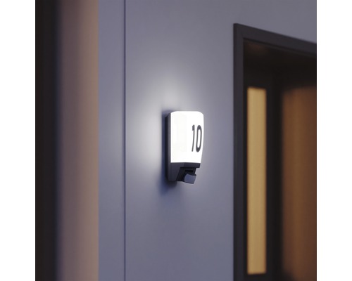 Placă de număr de casă iluminată cu numărul 10 pe perete