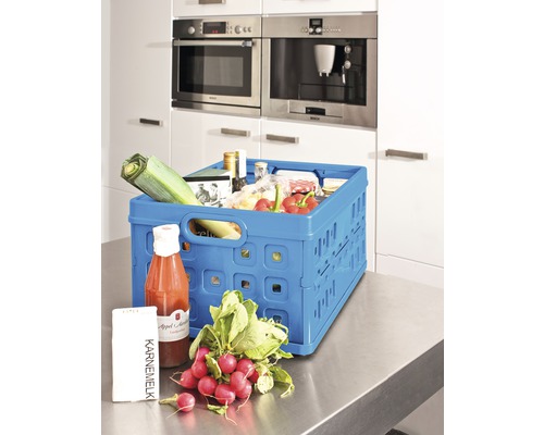 Un coș pliabil albastru cu produse alimentare pe un blat de bucătărie.