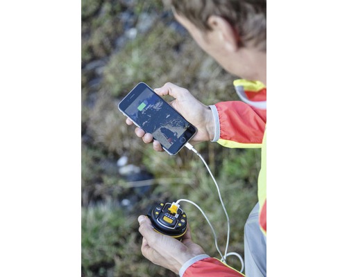 Un bărbat încarcă un smartphone cu un încărcător.