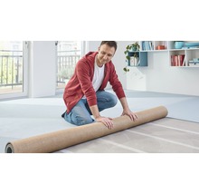 Bărbat întinzând covorul într-o cameră