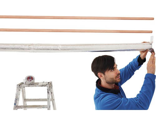 Un bărbat izolează o țeavă de încălzire cu bandă adezivă