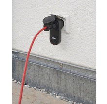 Încărcător auto electric cu cablu roșu conectat la o priză de perete