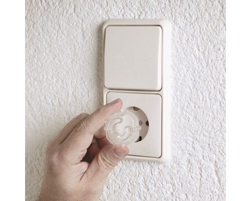 Mână care introduce protecție pentru copii în priză