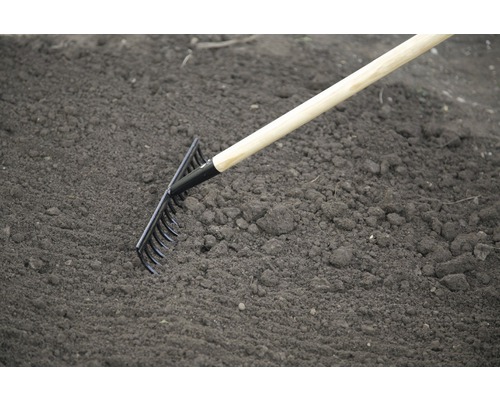 Greblă de grădină cu mâner de lemn utilizată pe pământ