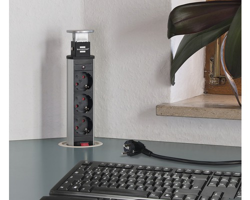 Bloc de prize retractabil cu trei prize pe un birou.