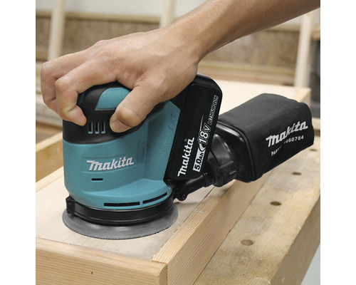 Șlefuitor orbital cu acumulator Makita în utilizare pe lemn