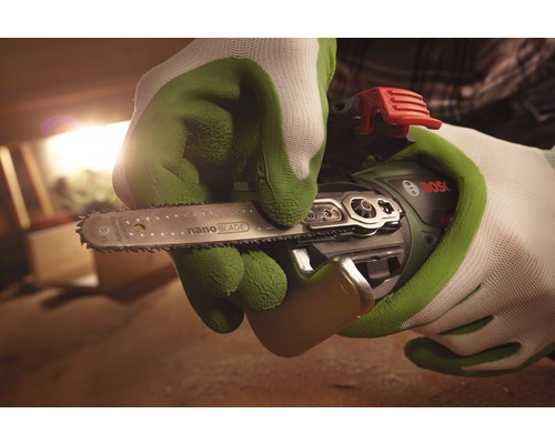 Persoană cu mănuși ținând un ferăstrău cu lanț fără fir Bosch cu lamă de ferăstrău NanoBlade