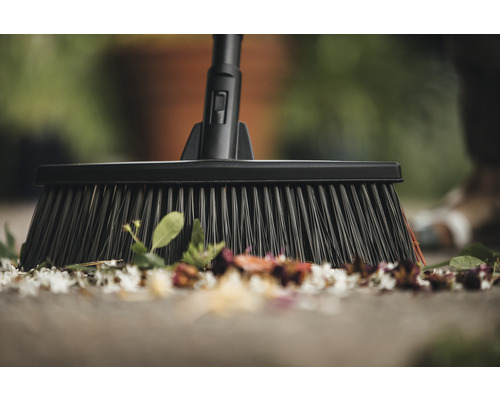 Mătură pentru curățarea frunzelor și petalelor pe o terasă.