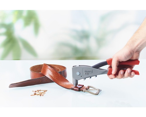 Un clește de nituit utilizat pe o curea de piele cu nituri