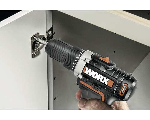 Șurubelniță fără fir care atașează o balama de un dulap