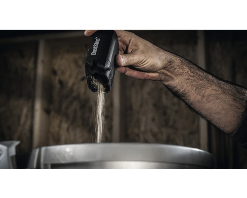 O mână toarnă praf dintr-un recipient de praf DustStop.