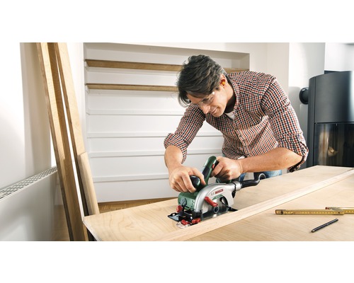 Bărbat taie o scândură de lemn cu un ferăstrău circular portabil, logo Bosch