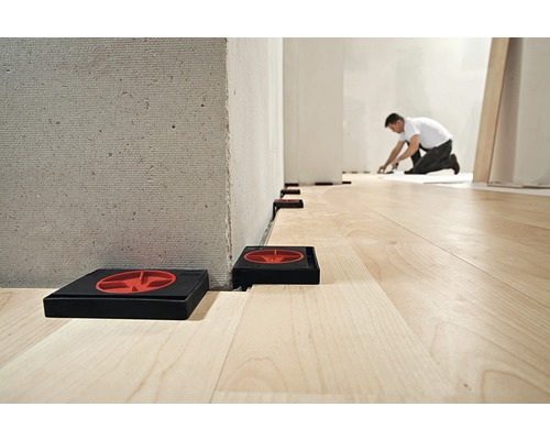 Montare laminat cu distanțiere între perete și podea