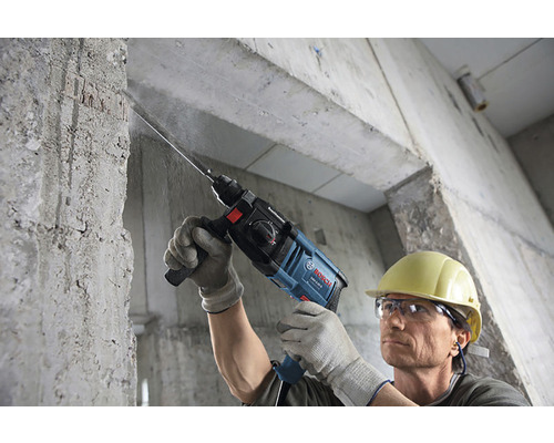 Bărbat găurește un perete de beton cu un ciocan rotopercutor