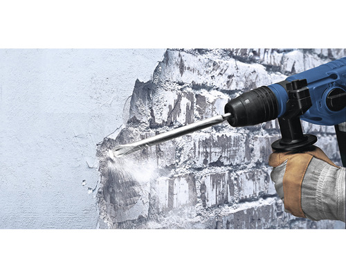 Un muncitor folosește un ciocan demolator pentru a lucra la un perete.