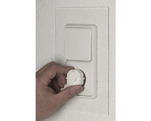 Mână introducând protecție pentru copii în priză