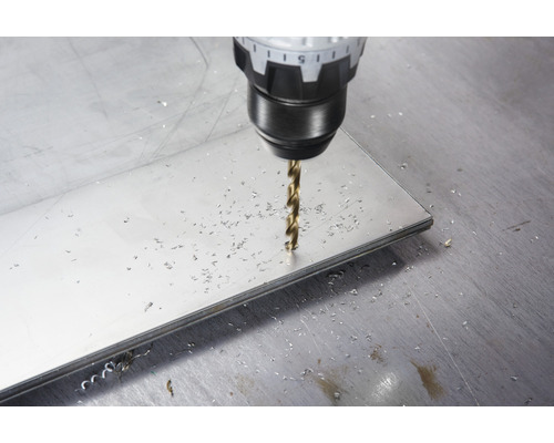 O mașină de găurit găurește o placă metalică.