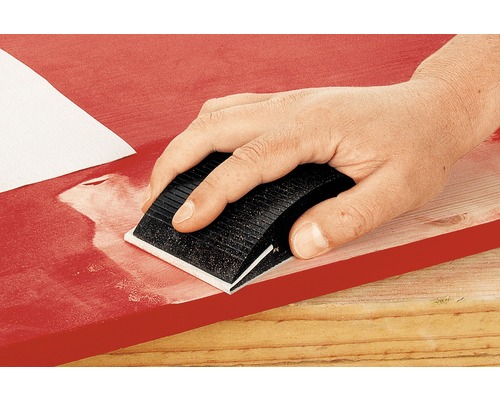 Mână șlefuind lemn cu bloc abraziv