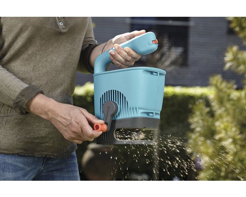 Persoană care folosește un distribuitor Gardena pentru grădinărit
