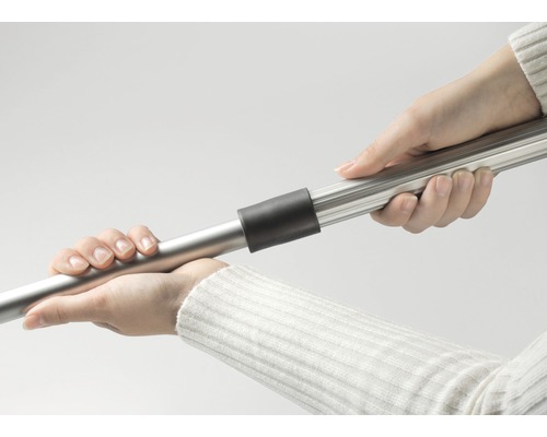 Două mâini țin un tub de aspirator.