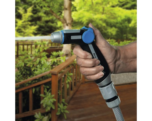 O persoană ține un cap de pulverizare pentru grădină din care iese apă.