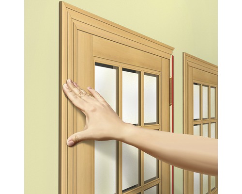 Mână atingând rama ferestrei din lemn