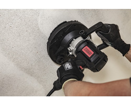 Artizan cu o șlefuitoare de gips-carton pe un perete