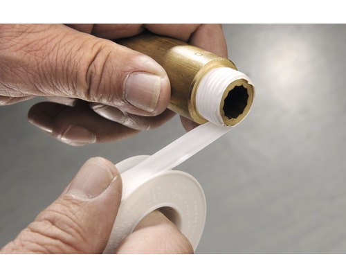 O persoană înfășoară bandă de etanșare în jurul unui filet