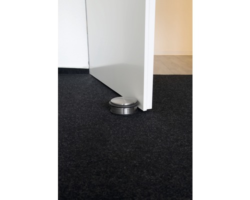 Opriitor de ușă metalic pe podea lângă o ușă