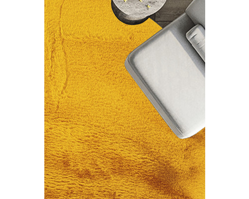 Prim-plan cu o cameră cu covor, canapea și masă.