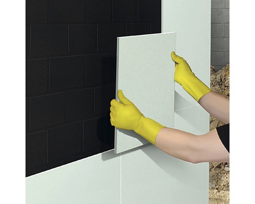 Persoană care montează plăci de faianță în baie
