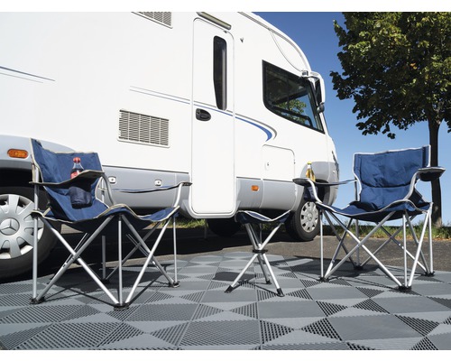 Camping cu două scaune de camping, taburet și rulotă pe plăci
