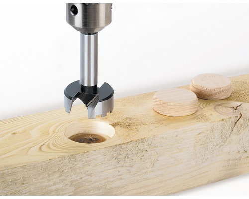 Burghiu Forstner folosit pe o placă de lemn cu dopuri de lemn