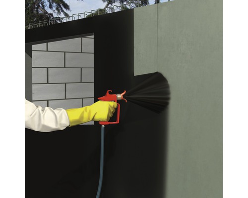 O persoană folosește un pulverizator pe un șantier.